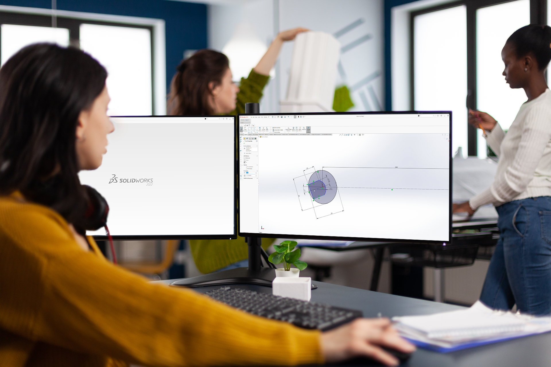 woman looking at two screens with solidworks 3d cad